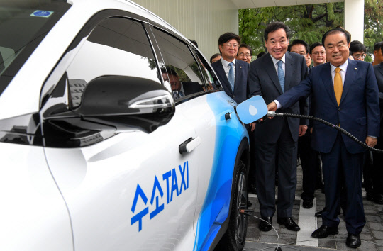 현대자동차는 10일 서울 여의도 국회에서 'H 국회 수소충전소' 준공식과 개소식을 갖고 서울 시내 첫 상업용 수소충전소를 운영한다고 밝혔다. 사진은 문희상 국회의장(앞줄 오른쪽부터), 이낙연 국무총리가 수소택시에 연료를 충전하는 모습. <현대자동차 제공>